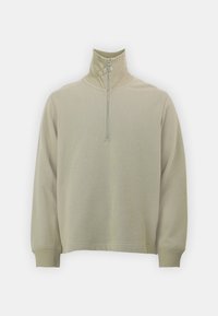 Lys beige genser med høy krage, halv glidelås foran, lange ermer og ribbestrikkede mansjetter. Myk tekstur, minimalistisk design.