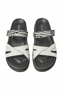 Weiße Riemchensandalen mit einem Zebra-Print-Riemen. Hergestellt aus synthetischem Material, mit einer glatten Textur und einer Gummisohle für besseren Halt.