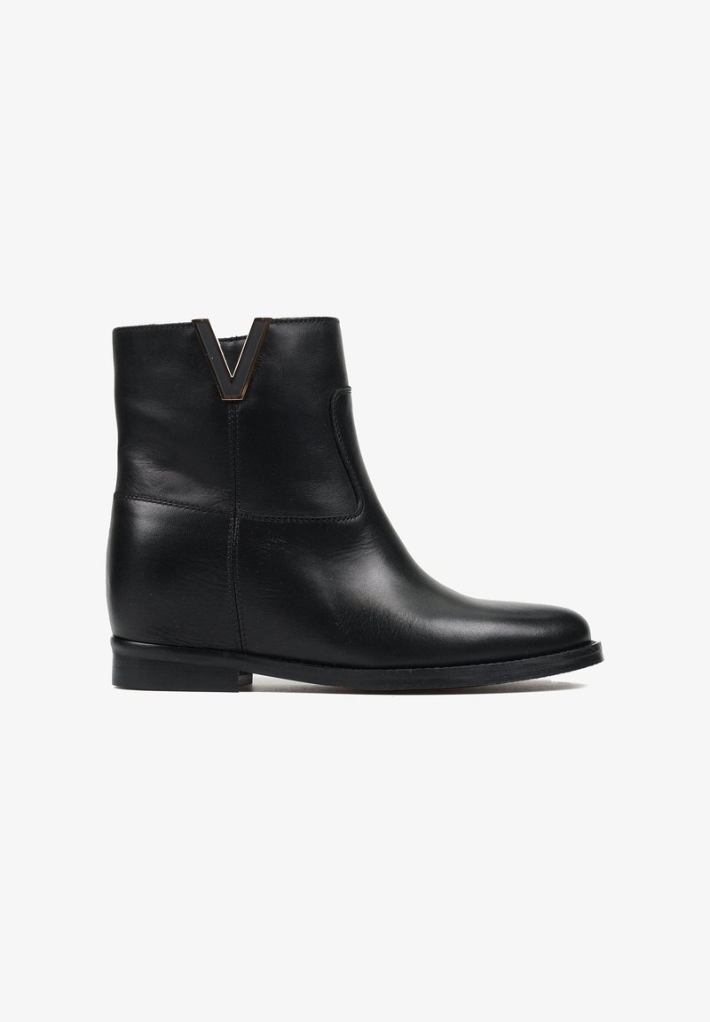 Czarne skórzane botki za kostkę z okrągłym noskiem, niskim obcasem i charakterystycznym złotym akcentem w kształcie litery V przy kołnierzu. Gładka tekstura, minimalistyczny design.