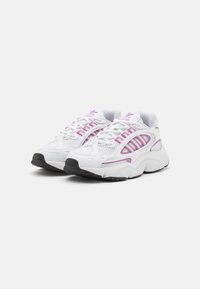 White athletic shoes featuring mesh material, purple accents, cushioned sole, textured outsole, and multiple lacing eyelets.