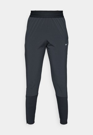 Nike träningbyxor i mörkgrått, med en tapered ben-design, elastisk midja och accentdetaljer nära muddarna.