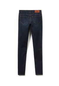 Jean en denim bleu foncé slim fit avec une texture lisse, doté d'une patch en cuir à la taille et de poches arrière standard avec des coutures décoratives.