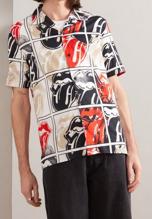 Camisa de manga corta con botones y patrón de rejilla con bocas abiertas estilizadas en colores rojo, negro, beige y blanco.