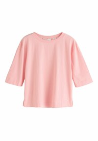 T-shirt rose pâle ample avec manches au coude et encolure ronde, suspendu sur un fond blanc.