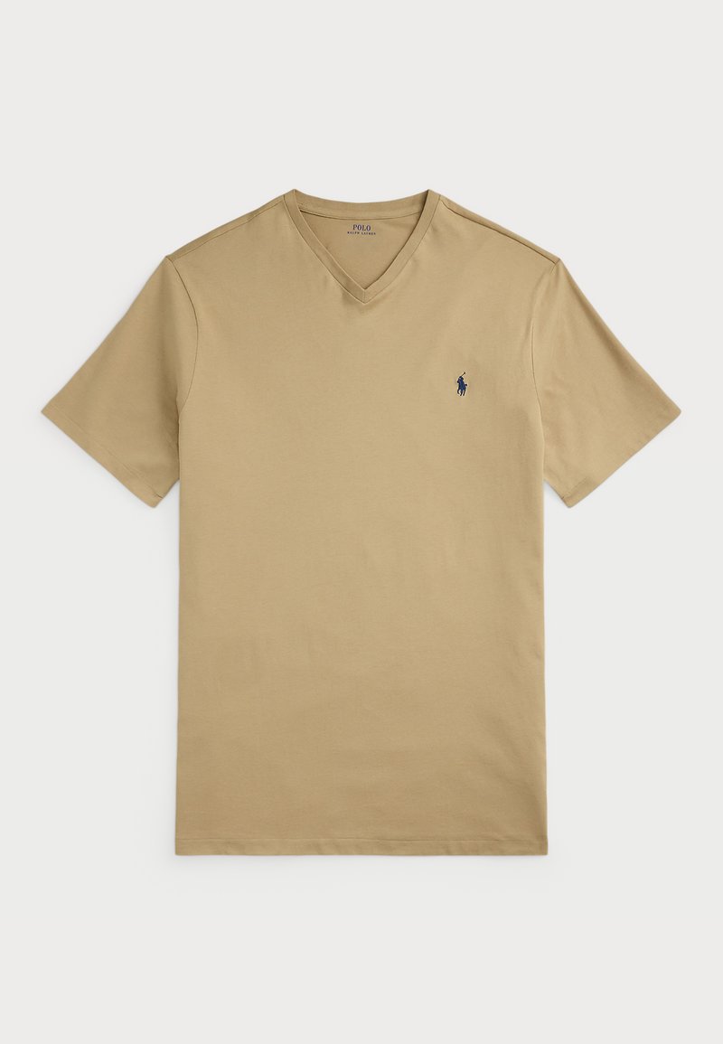 Beige v-hals t-skjorte laget av bomull med korte ermer. Har en liten marineblå logo på venstre bryst og en jevn tekstur.