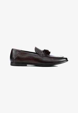 Mocasines de hombre de cuero marrón oscuro con borlas, tacón bajo y punta afilada, mostrados de lado sobre un fondo blanco.