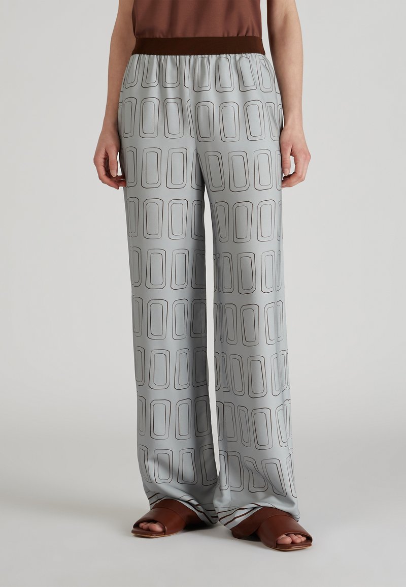 Pantalons larges gris avec un imprimé géométrique, dotés d'une taille élastique marron et d'un tissu lisse et léger.