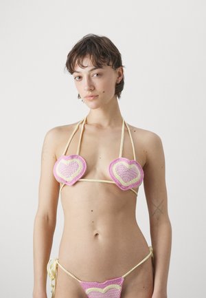 Crochet bikini featuring heart-shaped cups in pink and yellow, with string ties at the neck and sides, showcasing textured patterns.