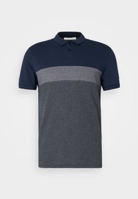 Polo à manches courtes avec un col bleu marine, partie haute unie bleu marine, bande grise au milieu et partie inférieure texturée bleu marine et blanche.