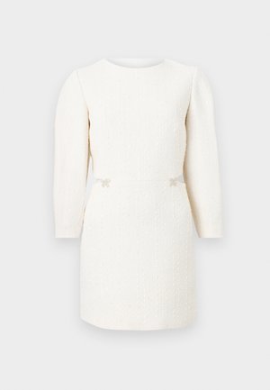 Λευκό μακρυμάνικο μίνι φόρεμα με υφή, στρογγυλή λαιμόκοψη και διακοσμητικά μικρά φιόγκια στη μέση, σε απλό φόντο.