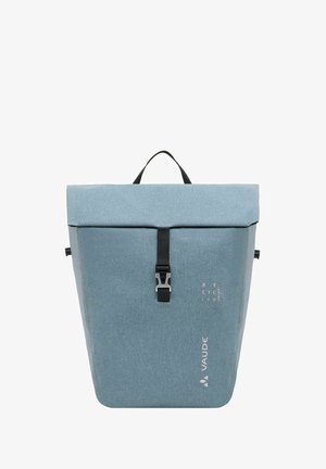 Sac à dos en tissu recyclé bleu avec un design à rabat, fermeture à boucle noire et une poignée de transport. Présente un logo et une texture subtils.