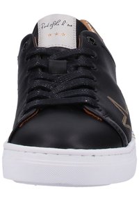 Černé kožené tenisky se zlatým akcentem, kulatá špička, plochá bílá gumová podrážka a tradiční šněrování. Branding na jazyku.