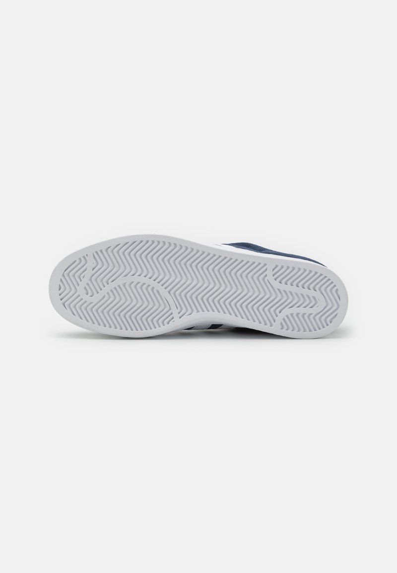 Marine sneaker met een witte rubberen zool met een visgraatprofiel, zachte textiele bovenkant en minimalistische designelementen.