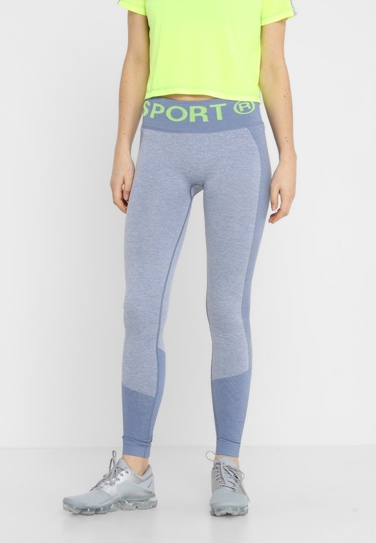 Legginsy sportowe o wysokim stanie w jasnoniebieskim kolorze z teksturowanym wzorem i kontrastującymi ciemnoniebieskimi akcentami. Posiadają zielony pas w stylu "SPORT".