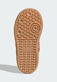 Adidas sneaker sole in beige rubber, featuring a textured, patterned surface with circular and diamond shapes, and embossed logo detail.