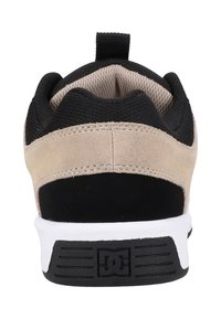 DC jalkineet. Musta verkkomateriaali, jossa on beige tekonahkaosioita, valkoinen välipohja, musta kumipohja ja kangaspidike kantapäässä.