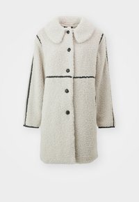 Fleecejakke i off-white med en stor krave, sorte knaplukninger og kontrastfyldige sorte vandrette linjer på ærmerne.