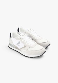 Zapatillas blancas de ante y malla con un acento gris claro, que presentan un logo de calavera en el lateral y una suela de goma negra.