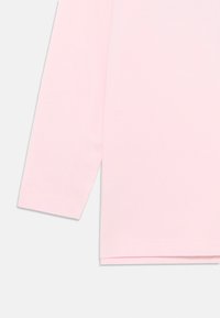 Lys rosa langermet skjorte med rette kanter på ermene og bunnen, vist mot en enkel hvit bakgrunn.
