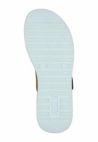 White rubber shoe sole with textured grooves and markings, slightly rounded at the toe, featuring a brown accent at the heel.