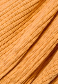 Orangenes geripptes Material mit strukturiertem Finish, das parallele Rillen und ein weiches, gestricktes Aussehen aufweist. Ideal für Bekleidung oder Accessoires.
