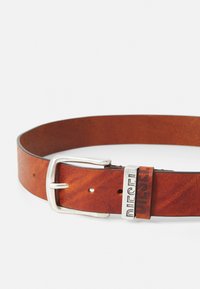 Ceinture en cuir marron avec une boucle en métal argenté. Présente un logo "DIESEL" estampé et plusieurs trous d'ajustement le long de la sangle.