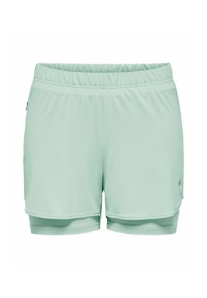 Vaaleanvihreät naisten kerrokselliset urheilushortsit, joissa on joustava vyötärönauha ja hillitty logo oikean alareiden kohdalla.