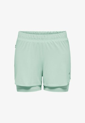 Vaaleanvihreät naisten kerrokselliset urheilushortsit, joissa on joustava vyötärönauha ja hillitty logo oikean alareiden kohdalla.