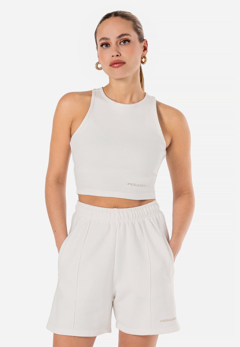 White ribbed crop top with a round neckline, paired with matching white shorts featuring an elastic waistband and side pockets.