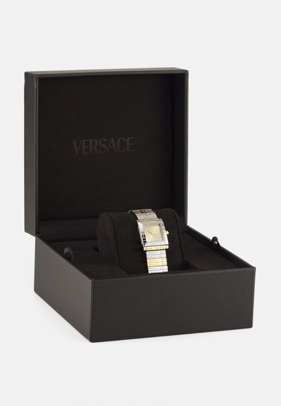 Versace kell mustas karbis. Roostevaba teras koos kuldsete detailidega, ruudukujuline nägu ja tekstureeritud rihm. Kasti siseosa mustast sametist.