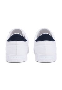 Λευκά πάνινα παπούτσια με ναυτικό μπλε υφασμάτινες λεπτομέρειες στη φτέρνα, ραμμένα σχέδια και λαστιχένια σόλα. Λογότυπο ανάγλυφο στη φτέρνα.