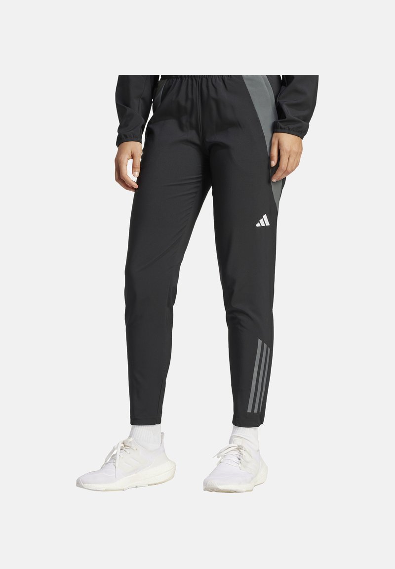Schwarze Sporthose mit elastischem Bund, ausgestattet mit einem grauen Seitenpaneel und drei weißen Streifen am Unterschenkel. Hergestellt aus leichtem Material.