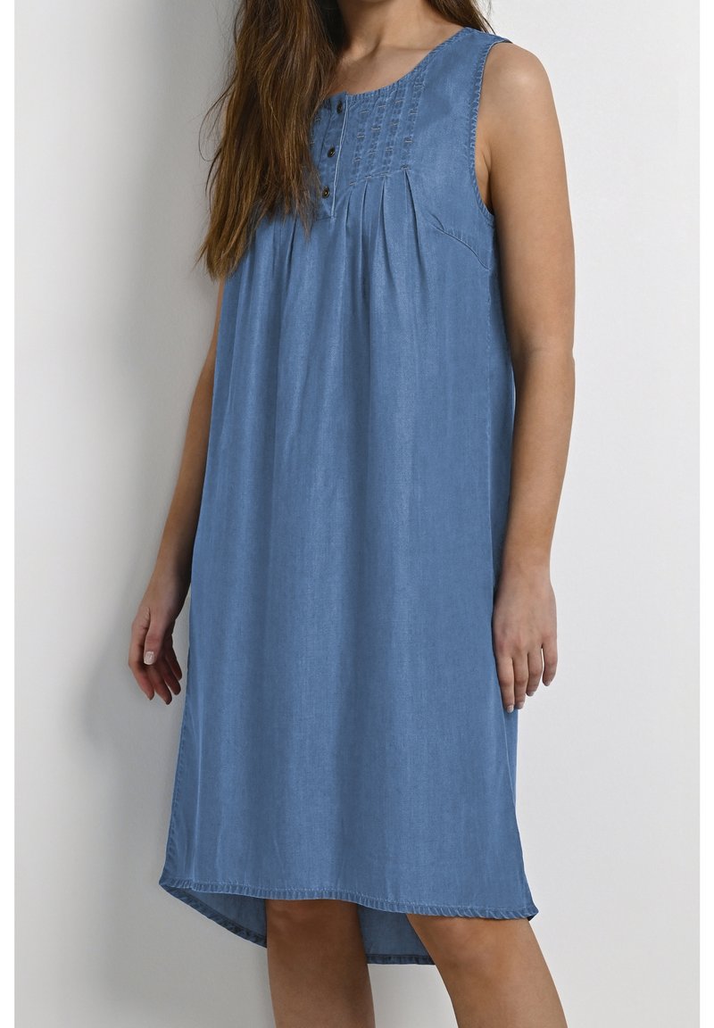 Robe en denim bleu clair, design sans manches avec un col rond, boutons décoratifs et tissu froncé pour la mise en forme. Ourlet légèrement courbé.