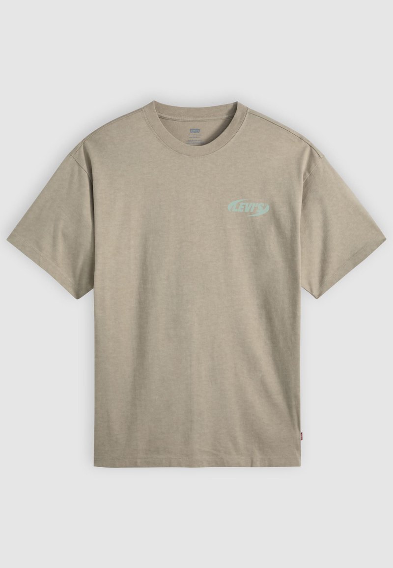 T-shirt beige col rond à manches courtes avec un petit logo "Levi's" bleu clair sur le côté gauche de la poitrine et une étiquette rouge sur la couture latérale.