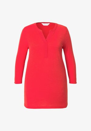 Vestido rojo de manga larga con escote en V y detalles de tapeta texturizada. La tela es suave y el vestido tiene una forma de corte A, llegando a la mitad del muslo.