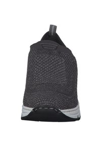 Gray knitted athletic shoe featuring a slip-on design, textured upper, rear pull tab, and contrasting white sole with black accents.