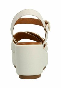 Witte hakken sandalen met een chunky hak, verstelbare enkelbandjes en een bruin binnenvoering detail. Gladde textuur met minimale ontwerpelementen.