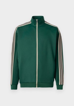 Grüne Zip-Jacke aus weichem, strukturiertem Stoff. Mit weißen und schwarzen Streifen an den Ärmeln und einem hohen Kragen-Design.