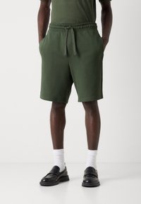 Grønne jersey shorts med elastisk talje og snøre. Har to sidelommer og en diskret logo detalje på benet.