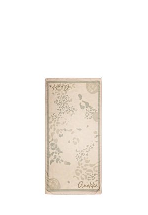 Asciugamano rettangolare beige con motivi astratti di foglie grigio chiaro, bordi rifiniti e testo "Anekke" stampato in due angoli.