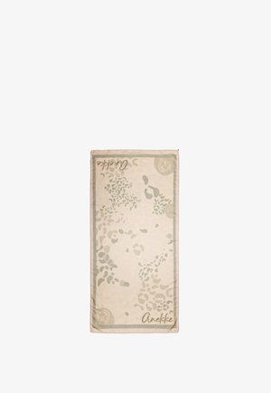Toalla rectangular beige con patrones abstractos de hojas en gris claro, bordes con ribete y texto "Anekke" impreso en dos esquinas.