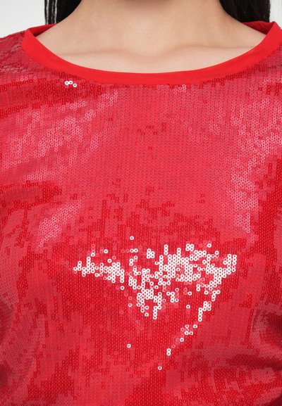 Punane litritega top ümmarguse kaelusega. Omadused hõlmavad tekstuurse pinnaga erinevates sädeleva litrite toonides ning südamekujulist mustrit läikivate aktsentidega.