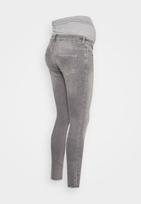 Vaqueros ajustados grises con una cinturilla suave y elástica. Presentan bolsillos traseros y un lavado desgastado para un aspecto casual. La tela es denim con una textura suave.