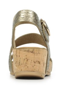 Sandale à plateforme en liège avec un dessus texturé doré métallique, des sangles ajustables et un accent décoratif en forme de fleur sur le côté.
