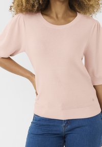 Jasnoróżowy sweter z dzianiny o okrągłym dekolcie, krótkich bufiasnych rękawach, prążkowanym wykończeniu i małym logo na dolnej stronie.