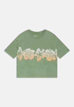 Oliven grønn kort t-skjorte laget av myk stoff, med et hvitt blomsterdesign langs kanten og rund halslinning.
