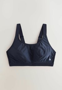 Reggiseno sportivo blu navy con spalline larghe, realizzato in tessuto elastico e liscio. Presenta un logo triangolare e cuciture per il supporto.