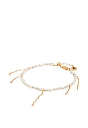 Pulsera delicada con perlas blancas de agua dulce, acentos de cadena dorada, cierre de langosta y un pequeño charm de corazón dorado con detalle de esmalte negro.