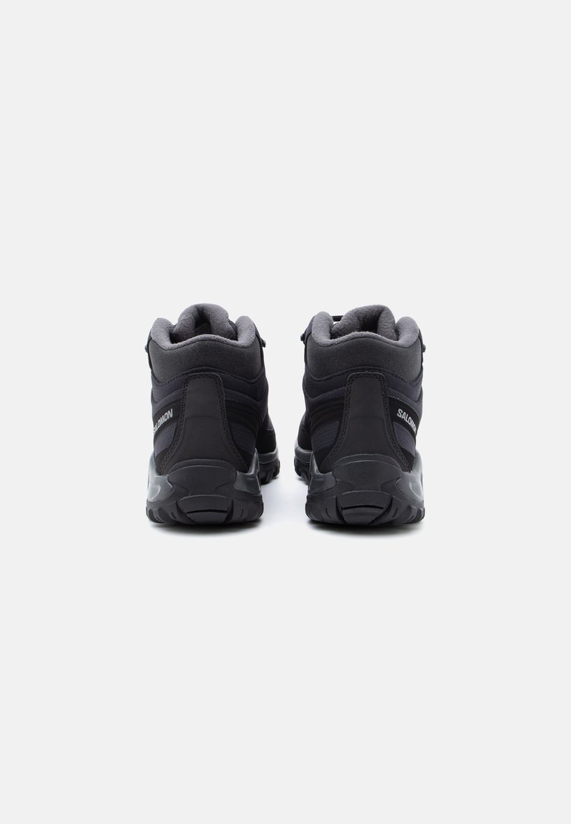 Sorte vandresko har en syntetisk overdel med polstrede kraver, en tekstureret gummiydersål og et broderet logo på siden.