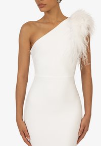Witte een-schouder jurk met een aansluitende silhouette. Heeft een textuuraccent met veren op de linkerschouder en een discreet ritsluiting.